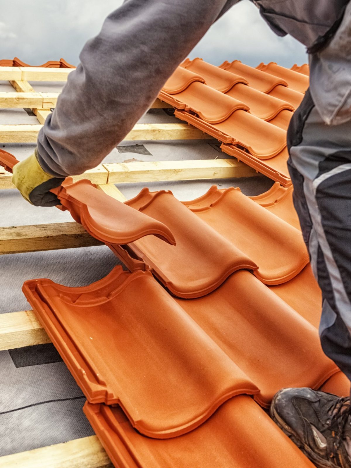 Roofer at work, installing clay roof tiles, Germany